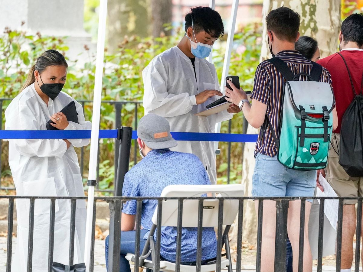 Healthcare workers with New York City Department of Health and Mental Hygiene help people register for the monkeypox vaccine at one of the city’s vaccination sites