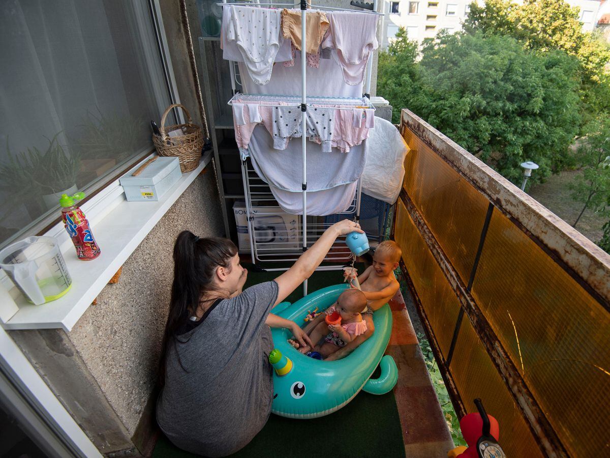 Krisztina and her children play on a balcony in Budapest, Hungary