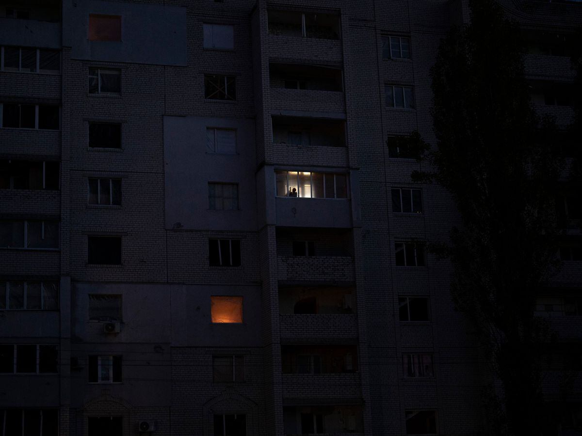 A man looks out the window of a building damaged by fighting between Ukrainian and Russian troops in Borodyanka, Kyiv region, Ukraine