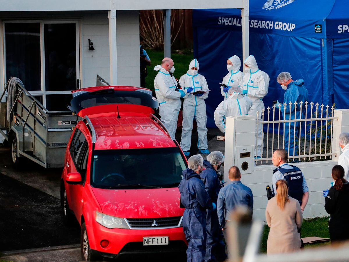 New Zealand Police investigators work at a scene in Auckland after body found in suitcase