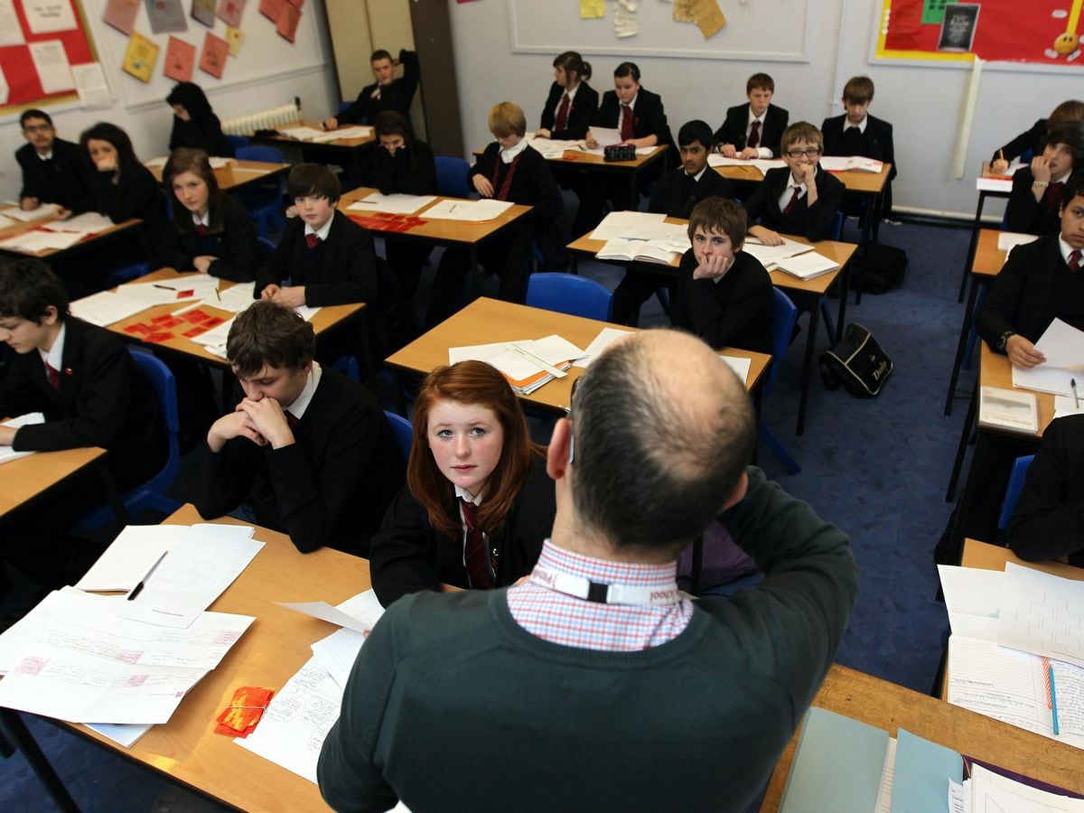 A teacher with a class of secondary school pupils