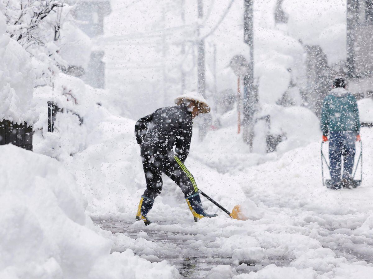 Residents remove snow during heavy snowfall in Nagaoka city, Niigata prefecture, northern Japan, on Monday