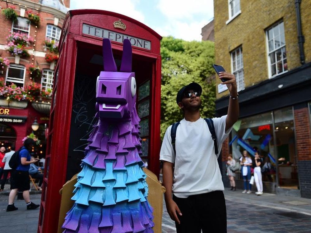 a man takes a selfie with a fortnite loot llama in a red telephone box on neal street in covent garden london - how to make a fortnite llama in real life