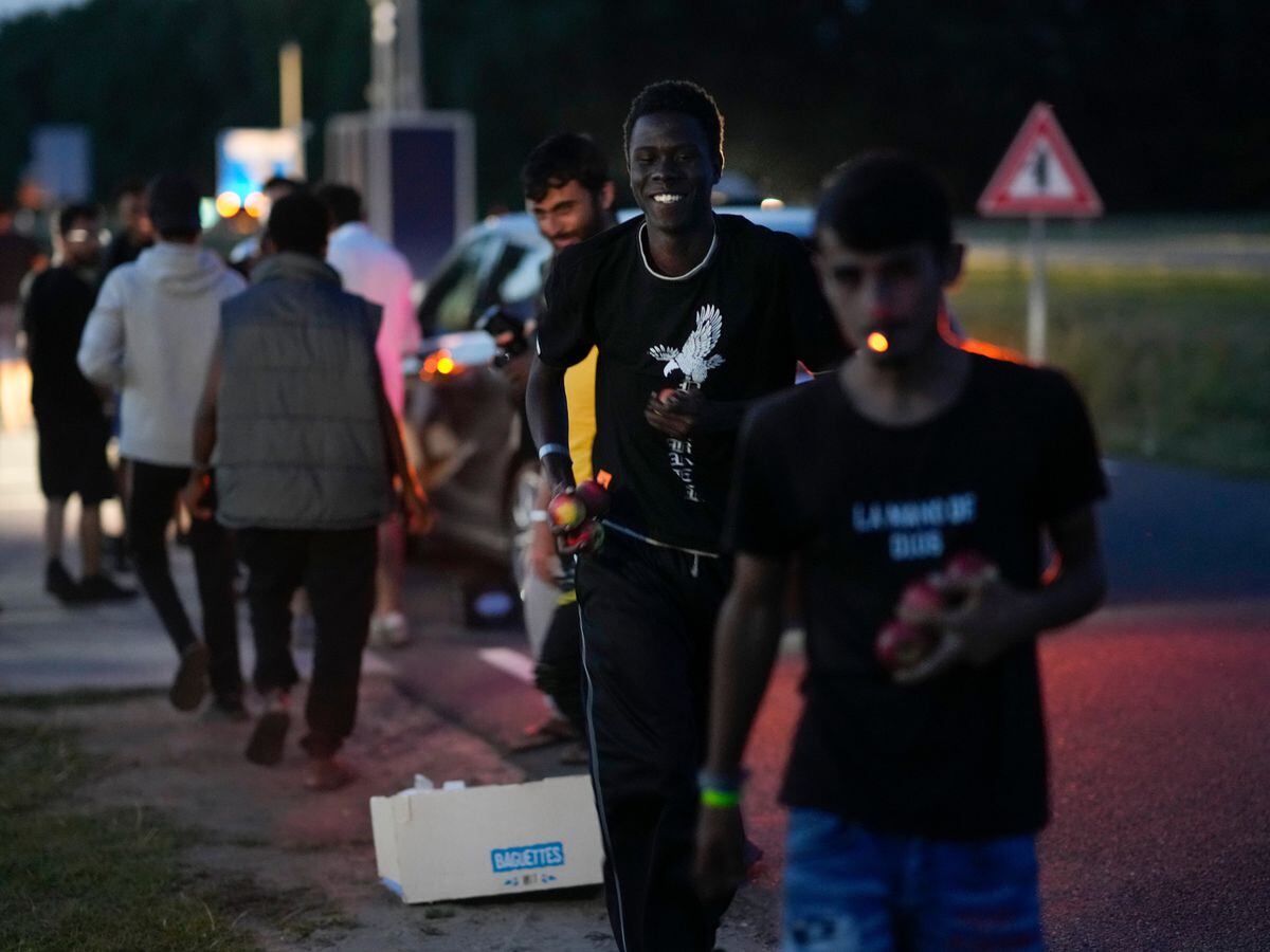 Hundreds of migrants prepare to spend the night outside an overcrowded asylum seeker centre in Ter Apel, northern Netherlands, as refugees flee with items handed out by passersby