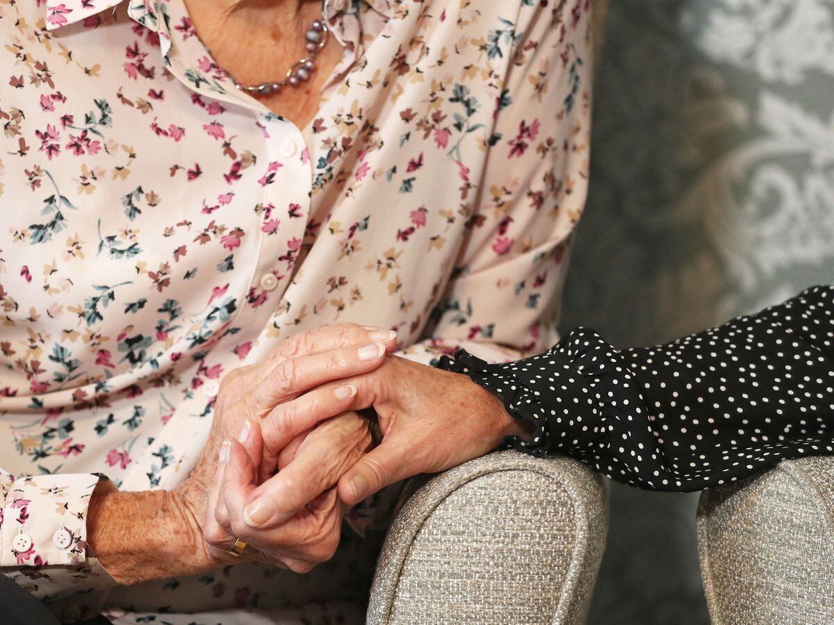 EMBARGOED TO 0001 SATURDAY SEPTEMBER 4..File photo dated 04/09/21 of a care home resident holding hands with her daughter. The Government is being warned of widespread closures of care homes unless it scraps the "no jab, no job" law in England. Issue date: Saturday September 4, 2021. PA Photo. The union said the controversial mandatory vaccination rule for England was pushing thousands of workers to the brink of quitting care work ahead of the September 16 deadline to get their first vaccination or face losing their job. See PA story INDUSTRY Care. Photo credit should read: Andrew Matthews/PA Wire .....