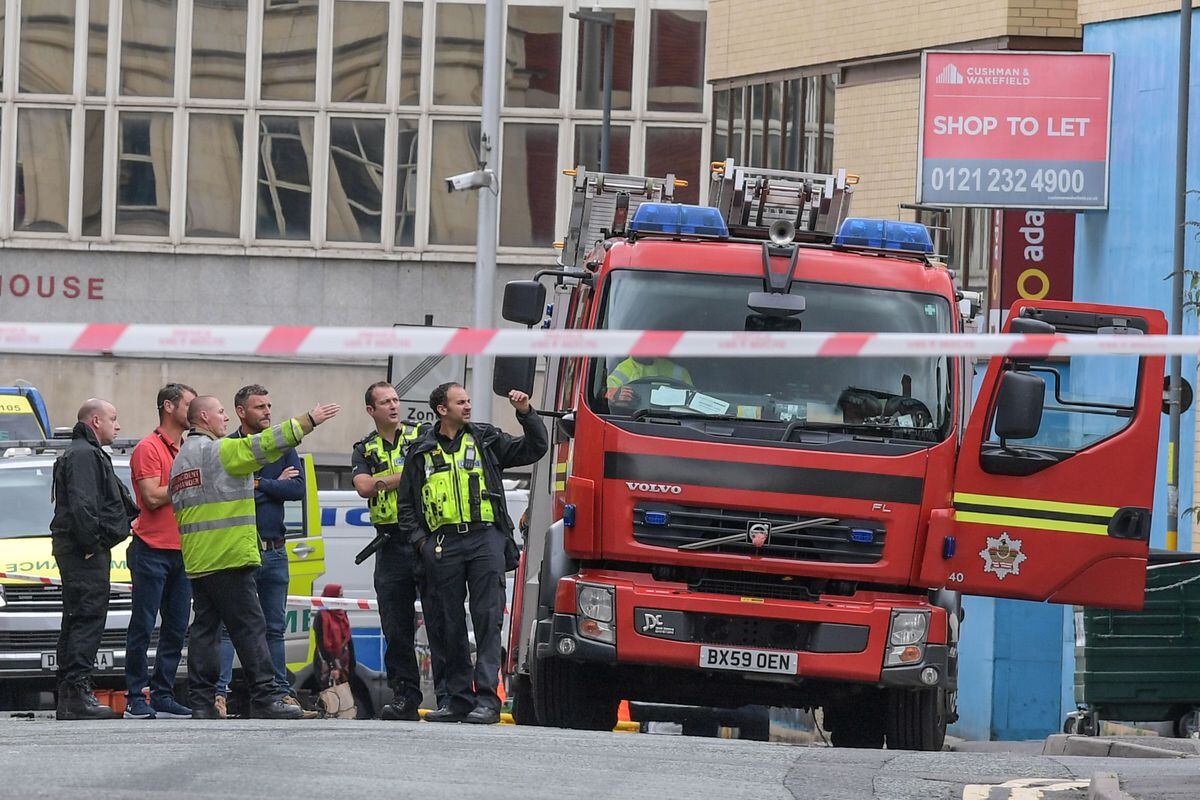 Road closed as police negotiate with man throwing debris from roof in