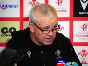 Warren Gatland, wearing glasses, talks to the media