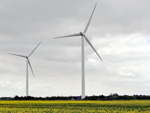 Wind farm turbines against a grey sky