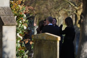 Former One Direction band member Niall Horan hugs another mourner as he arrives 