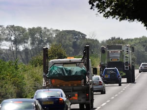 Traffic passing a combine harvester