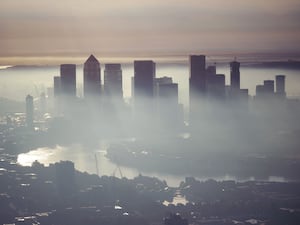 A view of the City of London through the mist across the River Thames