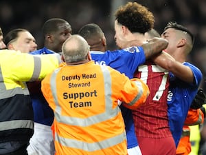 Liverpool’s Curtis Jones (centre) and Everton’s Abdoulaye Doucoure are separated by team-mates and members of the ground staff