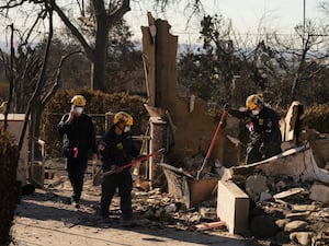 Search and rescue workers dig through the rubble left behind by the Eaton Fire in Altadena, California