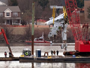 Rescue and salvage crews with cranes pull up the wreckage of an American Airlines jet