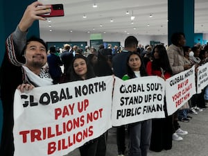 An activist takes a selfie during a demonstration on climate finance at Cop29