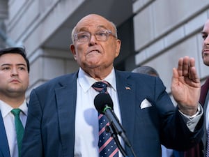 Rudy Giuliani gesturing as he speaks to reporters