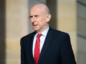 Defence Secretary John Healey wearing a dark suit with red tie