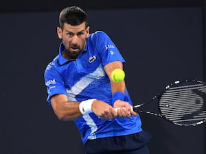 Novak Djokovic plays a backhand against Rinky Hijikata