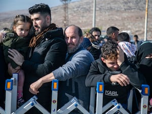 Syrians wait to cross into Syria from Turkey at the Cilvegozu border gate, near the town of Antakya, southern Turkey