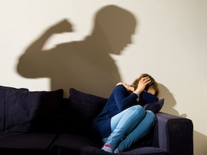 Stock image of the silhouette of a man threatening a woman