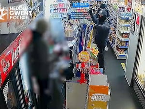 CCTV footage shows a shopkeeper being threatened by a man holding a weapon during a robbery in Newport