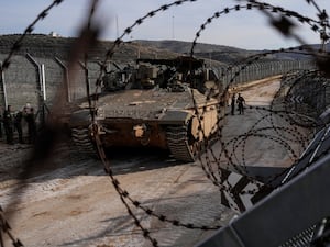 Israeli soldiers standing next to an armoured vehicle