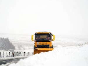 A snow plough and gritting lorry clears snow at Ribblehead, in North Yorkshire