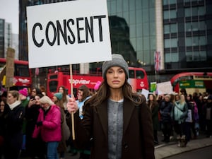 Vicky Pattison holds a sign saying 'Consent' during a protest