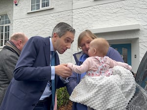 Simon Harris shakes a baby's hand