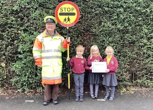 Lollipop man Stan Buller with pupils (from left) Toby Fowler, Winifred Twitchett and Chloe Priest 