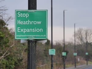 A sign on a lamppost reading 'Stop Heathrow expansion'