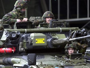 Three British soldiers in an armoured vehicle at Heathrow Airport