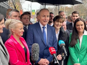 Micheal Martin sheltering under a brolly as he speaks to the media