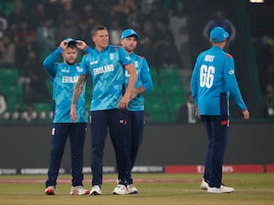 Brydon Carse, centre, grimaces after taking a wicket