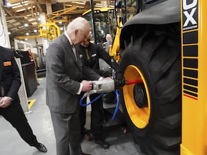 The King fits a tyre to a backhoe loader