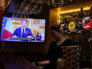 TV screen in a bar showing Emmanuel Macron