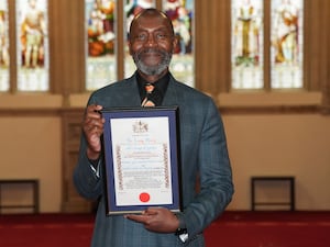 Lenny Henry holding a certificate