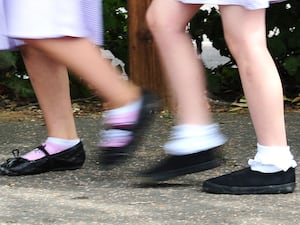 The legs of two young schoolgirls