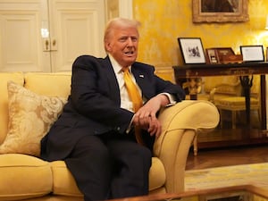 Donald Trump sitting on a sofa in the Oval Office