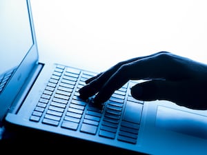 A woman's hand on a laptop keyboard