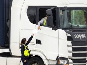 A Border Force officer returns papers to a haulage driver