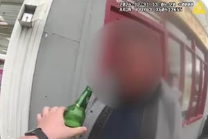 Man tries to take swig of his lager while being arrested for drink driving. 