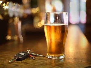 A pint of beer and a set of car keys on a bar in a pub in central London