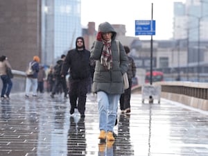 People battle wind and rain as they walk across London Bridge in stormy weather