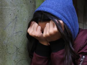 A teenage girl with her head in her hands.