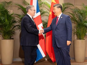 Prime Minister Sir Keir Starmer and Chinese president Xi Jinping shake hands in front of the flags of their respective nations