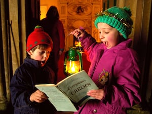 Children singing Christmas carols and holding a lantern