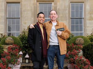 Two men standing in front of a mansion