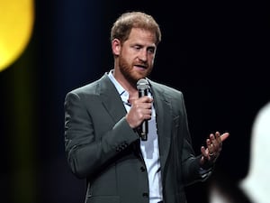 Prince Harry on a stage giving a speech