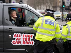 Police look on as a van joins a tool theft protest